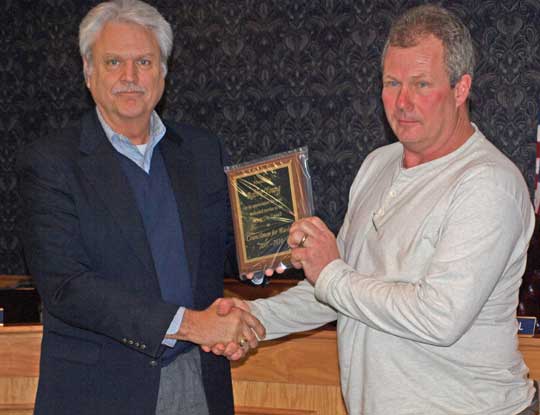 Ward 4 Alderman Robby Young accepts a plaque from Mayor Larry Mitchell.  The plaque represents the City’s gratitude for Young’s service as an alderman.  Young resigned from the position Thursday evening at the city council meeting. (Photo by Lana Clifton)