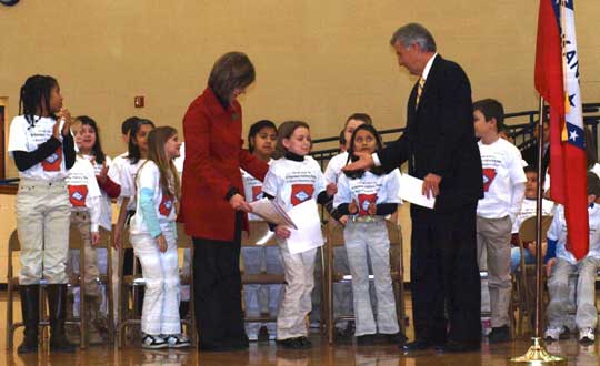 Governor Mike Beebe shakes hands with 3rd grade student, Peyton Adams.  Adams introduced Beebe as the featured guest of the event.