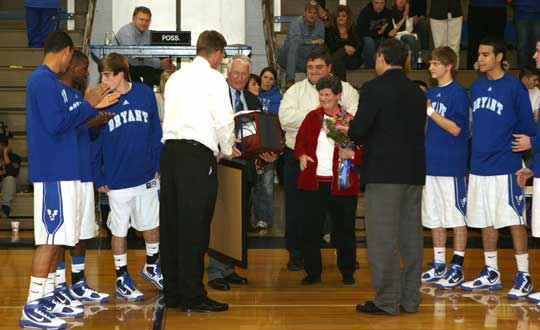 Bryant Hornets players along with superintendent Richard Abernathy, athletic director Tom Farmer and BHS principal Randy Rutherford presented coach Ron Marvel and his wife Jeanette with tokens of their gratitude for his stepping in a basketball coach this season. (Photo by Rick Nation)