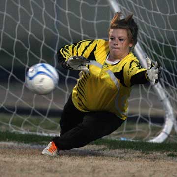 Keeper Kaitlin Miller lunges for the ball on her way to a save. (Photo by Rick Nation)
