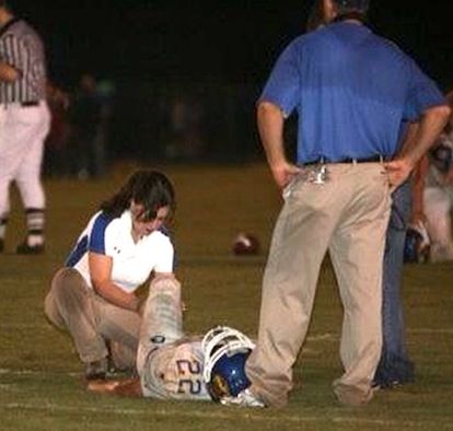 Athletic trainer Krista Finney tends to a Sheridan player during the Bryant-Sheridan football game in 2008. (photo by Rick Nation)