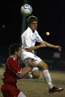 Reed Evans, shown here in a match earlier this season, heads the ball over a defender. (PHoto by Rick Nation)