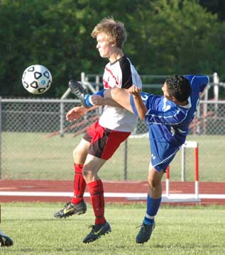 Carlos Garcia contorts to kick the ball free. (Photo by Mark Hart)