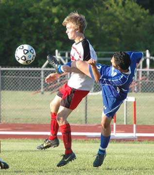 Carlos Garcia contorts to kick the ball free. (Photo by Mark Hart)