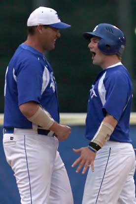 Bryant senior Brady Butler celebrates his two-run triple after being welcomed to third base by Bryant assistant coach Frank Fisher. (Photo by Rick Nation)