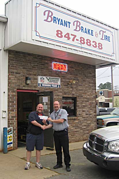 Shawn Omholt, left, accepts a $5,000 check from Ray Edwards of Auto Zone.