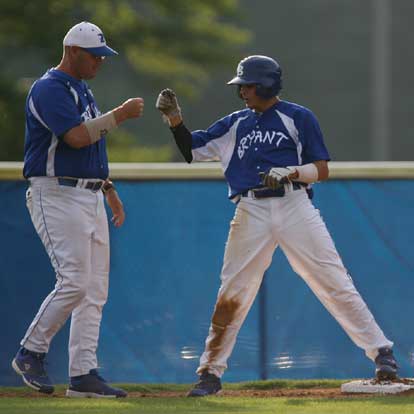 Garrett Bock bumps fists with third-base coach Frank Fisher after Bock's two-run triple capped a four-run sixth for Bryant against North Little Rock Monday. (Photo by Rick Nation)