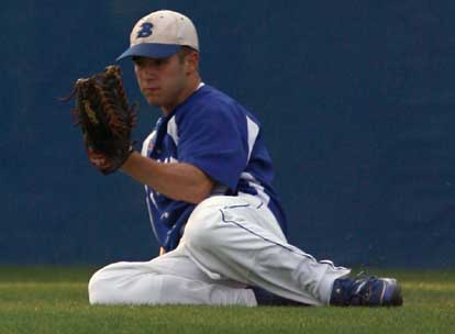 Bryant left fielder Brennan Bullock holds up his glove with the ball in it after making a sliding catch during Monday's game. (Photo by Rick Nation)