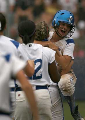 Stephanie Cyz jumps into the arms of a teammate to celebrate scoring the winning run in Tuesday's game. (Photo by Rick Nation)