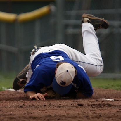Bryant first baseman Brady Butler does everything he can to block a seventh-inning grounder during the seventh inning of Saturday's 3-2 Bryant win. (Photo by Rick Nation)