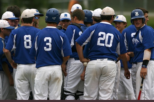 Head coach Kirk Bock gathers the Hornets around him for a meeting between innings. (Photo by Rick Nation)