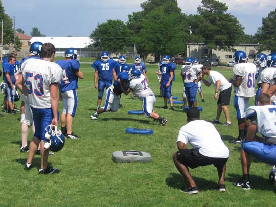 Bryant head coach Paul Calley, center right, encourages a pair of linemen during one-on-one work Monday.