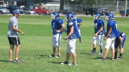 Secondary coach John Wells gives instruction to a group of defenders during Monday's practice.