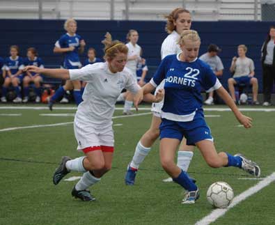 Lindsey Brazil, 22, holds off a Southside player to keep control of the ball. (Photo by Mark Hart)