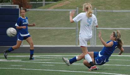 Sarenity Gomez, right, kicks the ball away from a Southside player as McKenzie Adams, left, gets back defensively. (Photo by Mark Hart)