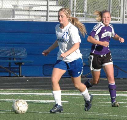Katie Moore (27) pushes the ball upfield during Monday's game. (Photo by Mark Hart)
