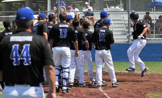 Cody Gogus is met at the plate by his teammates after his first-inning home run on Sunday. (Photo courtesy of Ron Boyd)
