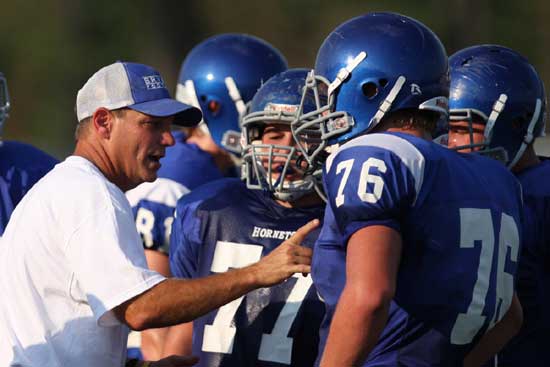 Offensive line coach Kirk Bock passes along a little instruction during a break in the action Monday. (Photo by Rick Nation)