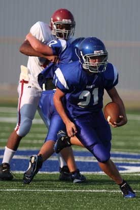Bryce Denker (21) cuts upfield off a block by teammate Colton Caviness (77). (Photo by Rick Nation)