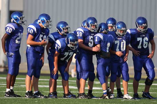 The Bryant freshman offense listens to quarterback Dakota Besancon in the huddle Monday evening. (Photo by Rick Nation)