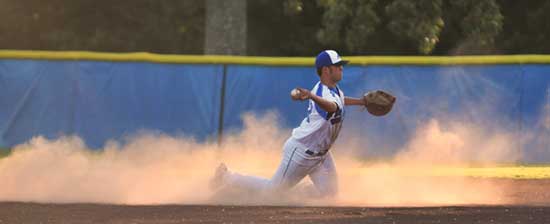 Infield dust flies as Tryce Schalchlin tosses to first after making a diving stop. (Photo by Ron Boyd)