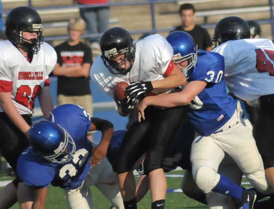 Bryant White's Austin Trusty (30) and Darquel Grey (32) bring down a Russellville East ball carrier during Thursday's game. (Photo by Kevin Nagle)