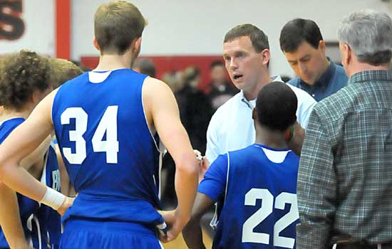 Bryant head coach Mike Abrahamson huddles with his team including Quinton Motto (34) and Marcus Wilson (22). (Photo by Kevin Nagle)