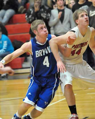 Bryant's Kyle Nossaman (4) battles with Cabot's Chuck Mantiione (44) for rebounding position. (Photo by Kevin Nagle)