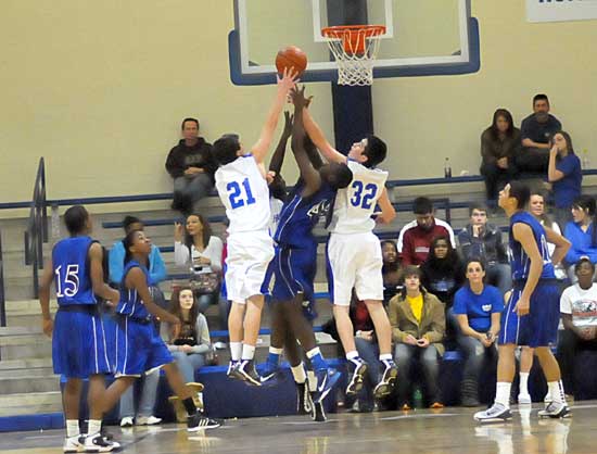 Bryant's Caleb Strain (21) and Mitch Scoggins (32) vie for a rebound during Monday's game. (Photo by Kevin Nagle)