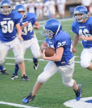 Kannon Porter (27) turns upfield as Ethan Burnett (50), Devon Alpe (34) and Chase Bailey (46) try to get into position to block. (Photo by Kevin Nagle)