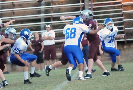 Bryant's Amador Gaspar (68) puts pressure on the Benton quarterback as James Gibson (94) and Jacob Stringer (70) close in. (Photo by Kevin Nagle)