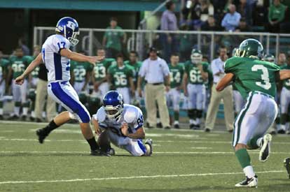 Jace Denker kicks one of his field goals out of the hold of Tyler Jamison as Van Buren's Anthony Gibbons (3) puts on the rush. (Photo by Ron Boyd)