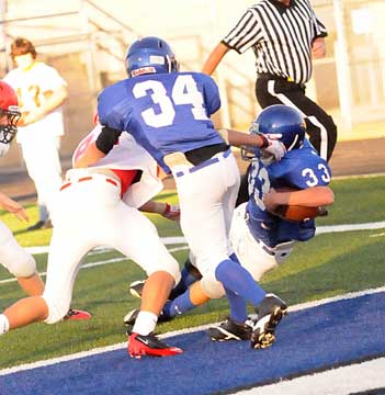 Devon Alpe (34) tries to help his twin brother Drew Alpe (33) as he scores Bryant White's lone touchdown. (Photo by Kevin Nagle)