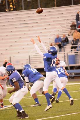 Quarterback Jaret Jacobs (13) reaches high for a snap as temmates Demaja Price (32), Cameron Murray (72) and Darrell Dieu (73) get set to block. (Photo by Kevin Nagle)