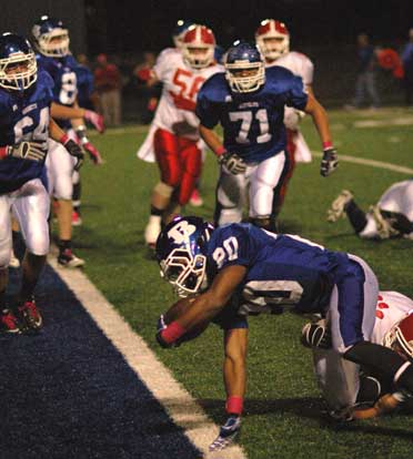 Jalen Bell strains to get into the end zone as teammates Seth Alkire (64), Nate Rutherford, and Blain Jackson (71) head his way. (Photo by Kevin Nagle)