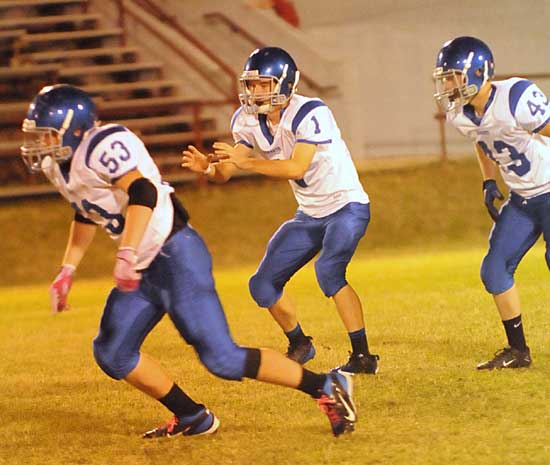 Ty Harris sets to receive a snap as Ryan Hall (53) and Brent Reeves (43) get started on the play. (Photo by Kevin Nagle)