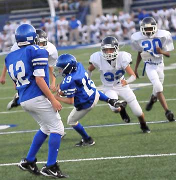 Bryant Blue's Logan Allen (19) hauls in a short kickoff as Conway's Brendan Camp (22) and the Hornets' Lawson Fincher (12) close in. (PHoto by Kevin Nagle)