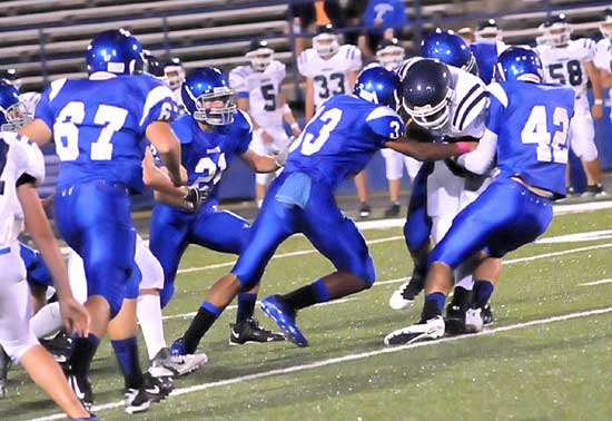 Brendan Young (33), Matt Shiew (42), Ben Bruick (21) and Devin Kelly (67) arrive to help a teammate bring down Conway White running back Kevin Chamorro. (Photo by Kevin Nagle)