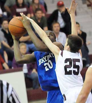 Bryant's J.C. Newborn (20) gets a shot away over Benton's Nathan Hubble. (Photo by Kevin Nagle)