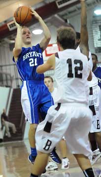 John Winn (21) pulls up in the lane for a jumper over Benton's Braden Warhurst (12). (Photo by Kevin Nagle)