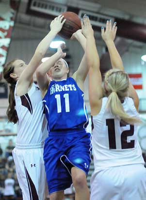 Bryant's Logan Davis (11) goes up for a shot in traffic after a drive to the basket against Benton's Korie Parker (12). (Photo by Kevin Nagle)