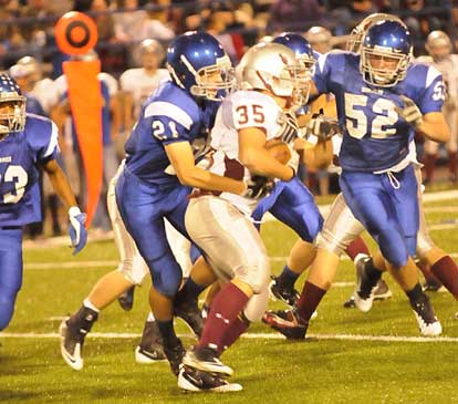 Ben Bruick (21) latches onto Benton running back Chase Shamlin as teammate Austin Trusty (52) charges in to help out. (Photo by Kevin Nagle)