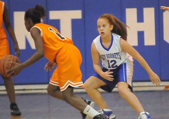 Bryant Blue's Kara Moser (12) defends a Ridge Road ballhandler during Thursday's game. (Photo by Kevin Nagle)