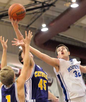 Bryant's Mitch Scoggins (32) battles with Catholic's Zach Morris (45) and Sam Greenwood (1) for a rebound. (Photo by Kevin Nagle)