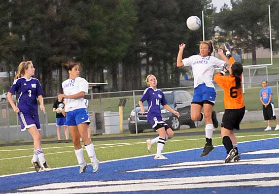 McKenzie Adams heads a ball clear in front of keeper Kaitlyn Miller and teammate Taylor Bryant. (Photo by Kevin Nagle)