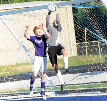 Bryant's Jace Denker goes hit to save a goal under duress from a Catholic player. (Photo by Kevin Nagle)