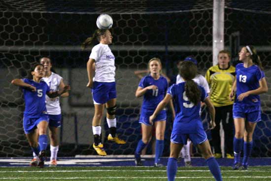 Bryant's Tarra Hendricks heads the ball out from in front of the Bryant goal to thwart a Conway attack. (Photo by Rick Nation)