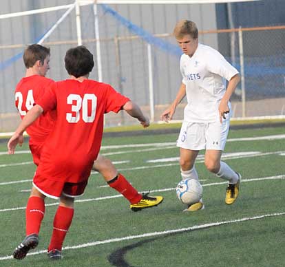 Reed Evans, right, looks for room to maneuver around a pair of Cabot players. (Photo by Kevin Nagle)