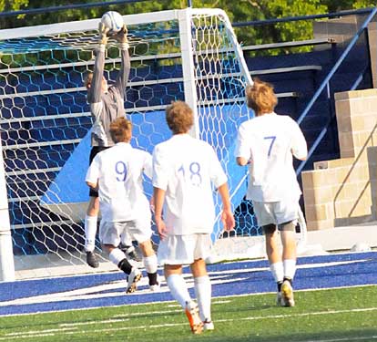 Bryant's Jace Denker goes high to latch on to a shot from Cabot as his teammates look on. (Photo by Kevin Nagle)