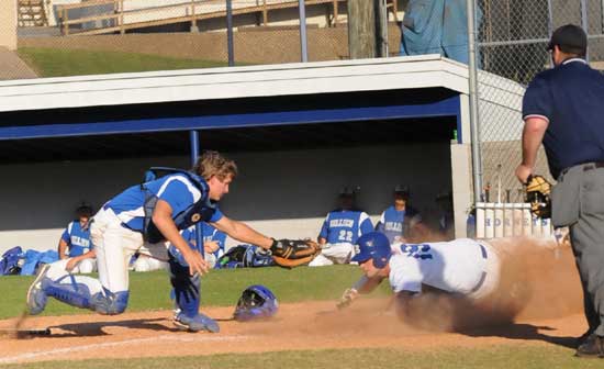 Bryant's Dylan Cross (19) slides safely past the tag of Monticello catcher Kameron Smith in the fifth inning of Friday's game. (Photo by Kevin Nagle)